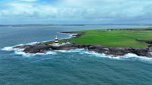 Ireland Epic Locations Hook Head Lighthouse landscape from the sea with the coast of Waterford in the background, Wexford view | Premium Stock Video Footage