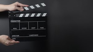 Download Movie clapperboard footage. Man hand holding film slate and clapping it in studio for free