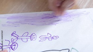 The boy paints people with colored felt-tip pens