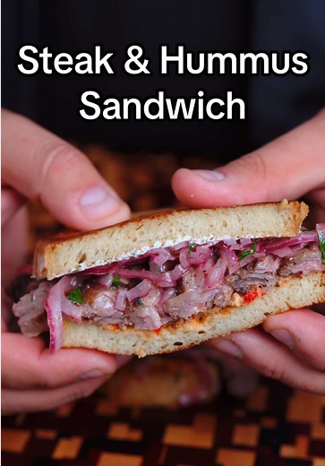 Steak & Hummus Sandwich is easily one of my top 3 sandwiches Sumac onions: • 1 red onion, thinly sliced • 1/4 cup chopped fresh parsley • 1 tbsp ground sumac • 2 tbsp olive oil • juice from 1 lemon • 1 tsp salt Steak sandwich: • Skirt Steak • Lemon Garlic butter marinade • sourdough bread • red pepper hummus - @sabrahummusdips • crispy onions • sumac onions • garlic & herb goat cheese 1. Start by trimming the skirt steak if needed, then getting it covered in the marinade and in the fridge for 24