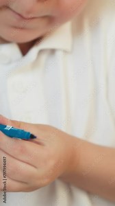 Little boy opens blue marker and takes triangular ruler at desk with copybook closeup. Toddler kid prepares to draw shapes with tool in classroom