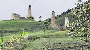 The Erzi tower complex in cloudy weather in spring. Panoramic view of the Erzi combat Towers complex, Republic of Ingushetia. Medieval military architecture of the Caucasus in the Dzheyrakh gorge