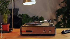 Retro Vinyl record player playing music, close-up macro shot of vintage LP disc old phonograph spinning. Retro music player at home.