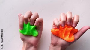 Playing with textured slime with bubbles, stretching the gooey substance. Female teen hand holding blue shining slime, squeezing it. Adorable Girl stretching slime toy to the sides. Liquid toy. 4K.