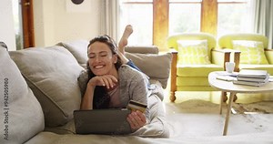 Woman on tablet, relax and credit card for online shopping, digital payment and fintech success on home sofa. Excited winner with yes for e commerce, subscription or sign up on banking app for a loan