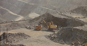Quarry truck driving on the road in deep quarry. A large mining truck transports ore. Dumper.