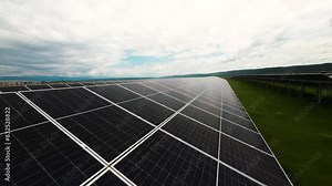 FPV drone video flying over a large solar panel field, showcasing renewable energy and sustainable technology in a vast landscape.