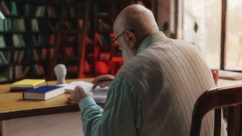 clip-4030017743-senior-professor-doing-historical-research-library-reading