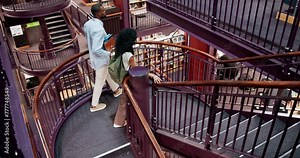 University, students and library walking with books for information, learning or knowledge for academic citation. Study session, top view or education resources and research literature with stairs