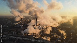 Polluting Factory at Dawn. Atmospheric air pollution from industrial smoke and dioxide. Industry pipes pollute the atmosphere with smoke