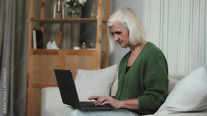 Close-up hands of grey hair Senior businesswoman grandma white woman using laptop computer at home. Medium shot of older Caucasian lady working on pc at the counter, old people and modern technology