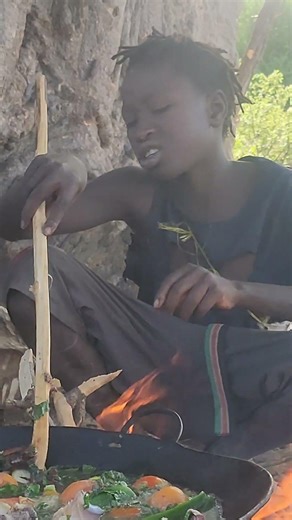 A young Hadzabe man preparing baboon meat soup for lunch.#Hadzabe #IndigenousCulture #USAaudience