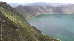 Experience the breathtaking beauty of the Quilotoa volcano crater lagoon in the majestic Ecuadorian Andes through a captivating pan shot.