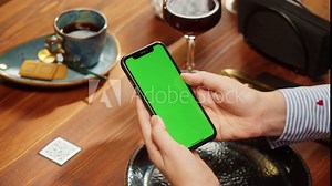 Woman using smartphone with chroma green screen, online menu in cafe. Scanning QR code in restaurant. Modern technology, ordering meal in application. Contactless touch-free payment in app.