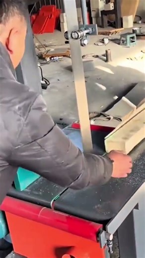 A person is cutting long wood using saw