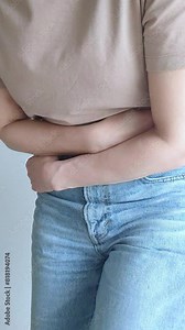Woman suffering from stomach ache, holding belly, feeling abdominal or menstrual pain. Gastritis, diarrhea and painful periods concept.