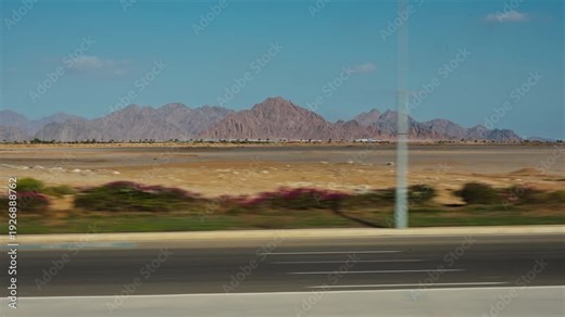 View from the window of an moving touristic bus. The bus is driving along the Ibn Sina road. Action takes place near Saint Catherine Protectorate, an Egyptian national park in the south of Sinai.