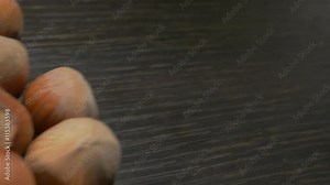 Hazelnut filberts on wooden surface slow dolly 4K 2160p UHD footage - Corylus avellana shells on table close-up dolly 4K 3840X2160 UHD video