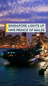 HMS Prince of Wales lit up at night in Singapore ✨⚓ New aerial photos show the Royal Navy aircraft carrier docked ahead of the next phase of her Indo-Pacific deployment. #HMSPrinceOfWales #AircraftCarrier #RoyalNavy #NavyLife #MilitaryPhotography #NightOps #SingaporePort #IndoPacificDeployment #NavalPower #ShipSpotting | Forces News