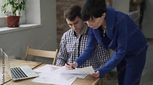 Woman explains the new employee what to do with graphics.