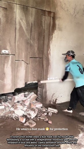 Construction Worker Demolishing Wall Safely with Dust Protection