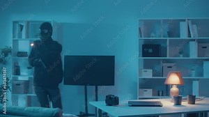 A Two Robber in Black Clothes and a Mask Broke Into House. A Criminals in the Night with a Flashlight and Gun Steals Safe. Night Vision Surveillance Cameras. Wireless Surveillance Cameras
