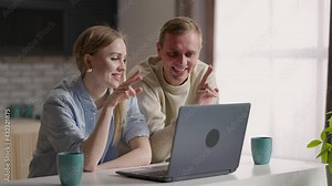 Married couple sit in kitchen making video call using internet and laptop device. Remote communication, pleasant videoconference conversation with family. Modern technology, apps usage concept