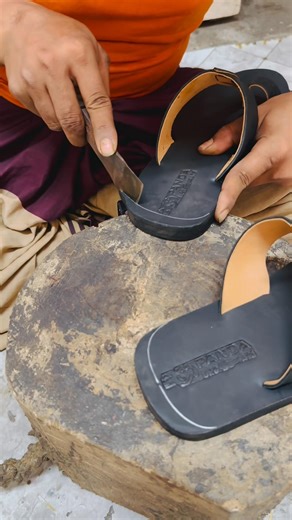 Large shoes are cut into smaller ones by hand.
