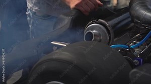 The exhaust pipe of a sport mouse releases smoke. Close-up