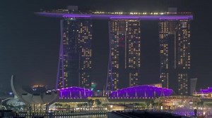 Fifty-five storeys high Marina Bay Sands Hotel dominates the skyline at Marina Bay in Singapore aerial night timelapse.