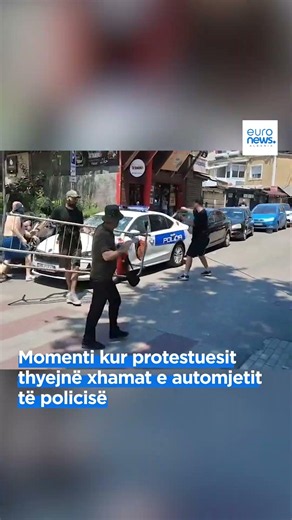 The moment protesters shatter the police vehicle's windows