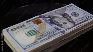 100 denomination US dollar bills stack rotating on an automatic table