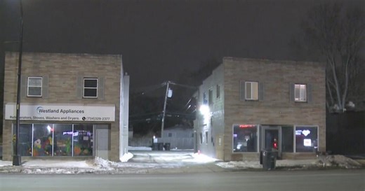 Person detained after vehicle crashes into building