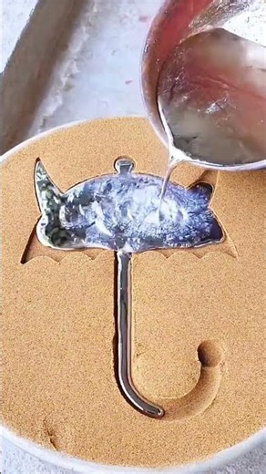 Casting whimsical umbrella-shaped metal design with cat ears