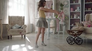 little girl spinning in a dress at home in the setting sun. slow motion