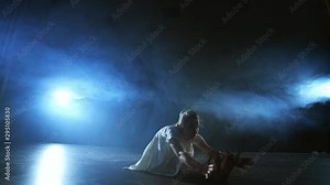 Modern ballet dancing woman barefoot lying on the floor doing spins and pirouettes and somersaults