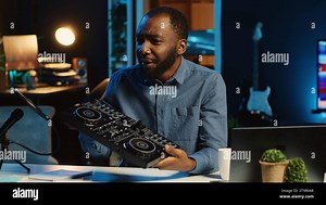 Tech content creator filming technology review of newly released DJ controller, unpacking it and presenting specifications to audience. Influencer showing disc jockey device to subscribers Stock Photo - Alamy