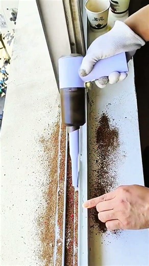 Vacuum cleaner removing dirt from window tracks