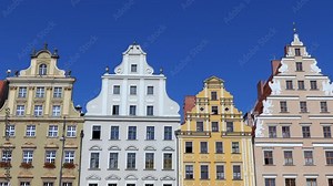 Facade of traditional buildings, houses in Market Square in the old city of Wroclaw, Poland, Europe. Polish landmark in the historic center of town. Clear blue sky with copy space