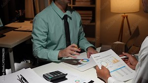 Businessman analyzing cost graphs in a conference room with a calculator and laptop with the new project of finance and accounting Presenting ideas and strategic plans at investment meetings.