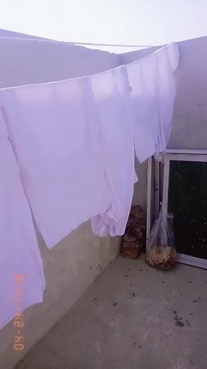 Loading Clothes into a Washing Machine Outdoors