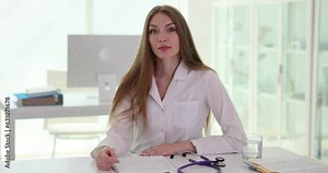 Specialist doctor sits at table during consultation at health facility. Female doctor examining patient in examination room slow motion