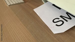 Printing “NO SMOKING” text written message on paper sheet document. Close up A4 page being printed from multifunction printer scanner on wooden desk in office. Male hand take paper from desk