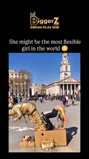 Inflyta on Instagram: "#biggerz The Instagram reel shares a 40-second video of a contortionist street performer in gold body paint executing extreme poses, such as wrapping her body around a pole and full backbends, alongside a levitating statue artist in London's Trafalgar Square, captivating onlookers with seamless collaboration. This performance features real artists, including Valentin the Levitating Gold Man and a highly flexible contortionist, as evidenced by similar viral clips on TikTok 