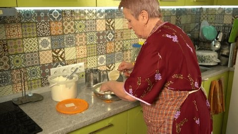 clip-4006658521-grandma-kneading-dough-her-hands-on-table