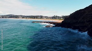 Drone aerial pan scenic shot of North Avoca beach coastline headland with point Central Coast tourism Pacific Ocean NSW Australia 4K