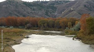 Looking upstream along Judith river at orange fall foliage