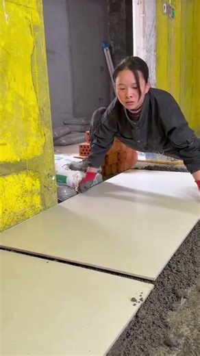 the process of installing large plain white ceramic tiles on the floor in a building room #popular