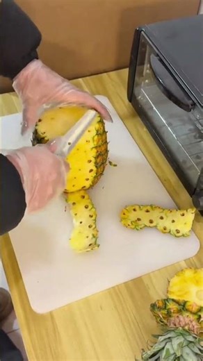 Experienced Chef Using Sharp Knife to Peel Fresh Pineapple Quickly and Efficiently