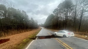 Sinkhole opens up in Athens amid heavy rains, swallowing car